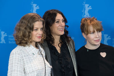 Portrait of happy friends against blue background