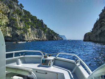 Boats sailing in sea against clear blue sky