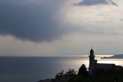 Scenic view of sea by building against sky during sunset