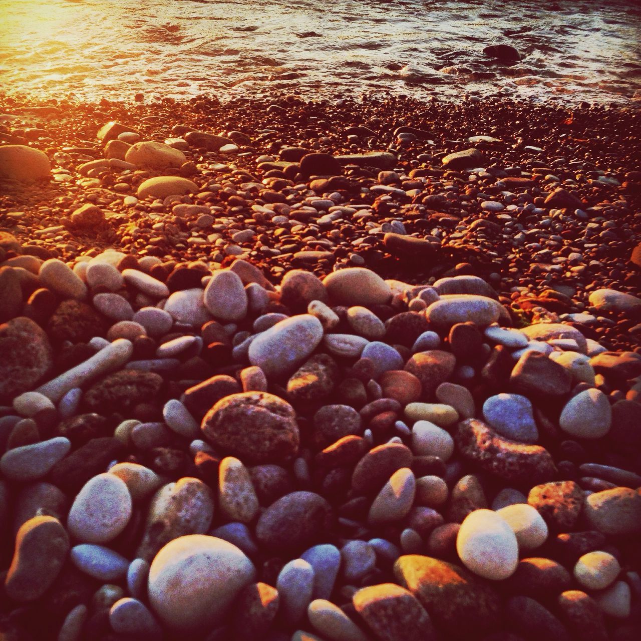 beach, pebble, shore, stone - object, sea, water, large group of objects, abundance, sand, rock - object, nature, tranquility, seashell, stone, outdoors, no people, backgrounds, beauty in nature, textured, day