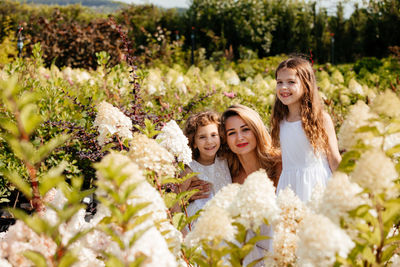 Portrait of a smiling young woman against plants