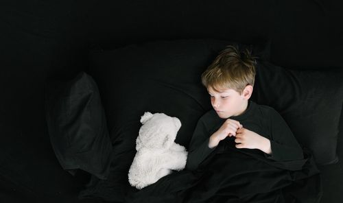 Young man sitting on black background