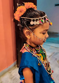 Girl in traditional clothes standing at home