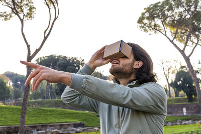 The young man in rome observes a virtual reconstruction with a cardboard viewer. 