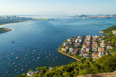 High angle view of city by sea against sky