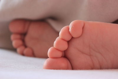 Low section of baby sleeping on bed