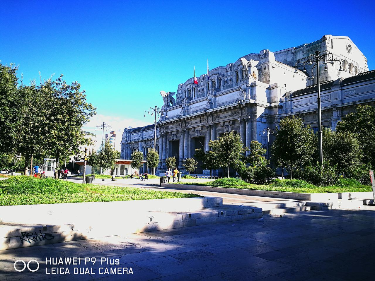 architecture, built structure, building exterior, clear sky, tree, blue, day, surface level, outdoors, footpath, no people, city life, history