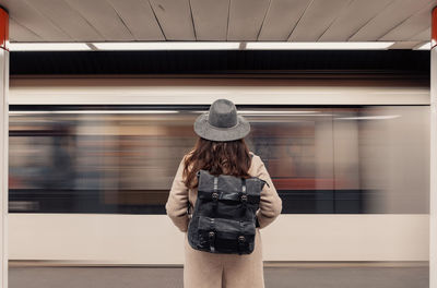 Rear view of woman standing in train