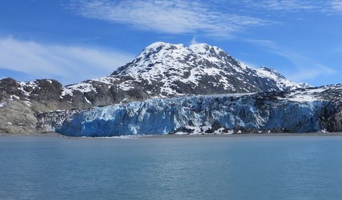 Scenic view of snowcapped mountains against glacier and blue sky