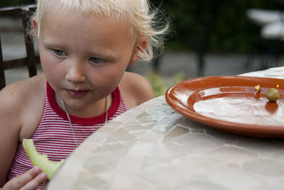 Cute girl eating food at table