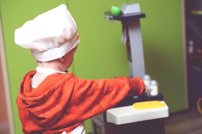 Rear view of boy preparing food