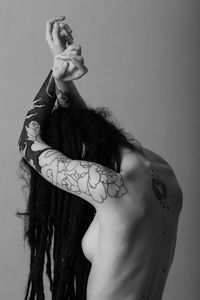Sensuous naked young woman with tattoo over white background