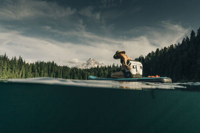 A young woman enjoys a standup paddle board on lost lake in oregon.