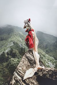 Man on rock against sky