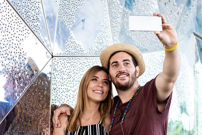 Happy couple taking selfie on the street during holidays trip