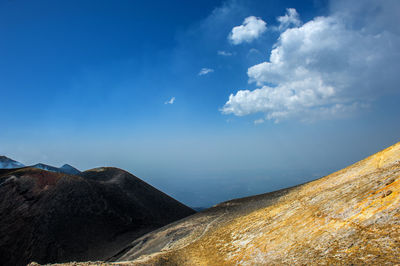 Scenic view of mountains against blue sky