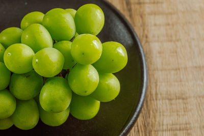 High angle view of grapes in bowl on table