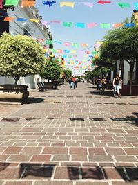 People on street in city against sky