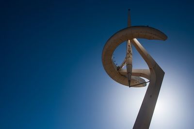 Low angle view of communications tower against clear blue sky