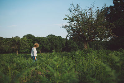 Woman standing on field against sky