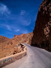 Road leading towards mountains against sky