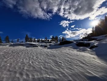 Scenic view of snow covered land against sky