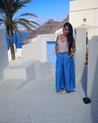 Full length of young woman standing against built structure