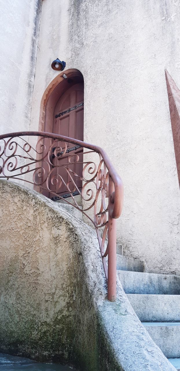 LOW ANGLE VIEW OF WOMAN STANDING AGAINST WALL