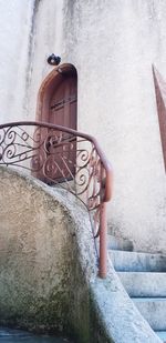 Low angle view of woman standing by staircase against building