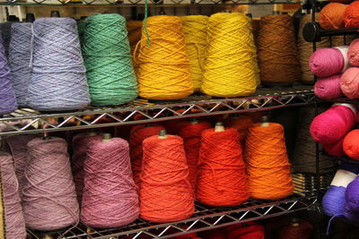 Full frame shot of colorful thread spools on rack