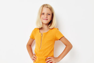 Portrait of young woman standing against white background