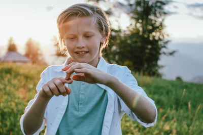 Portrait of cute girl holding plant on field