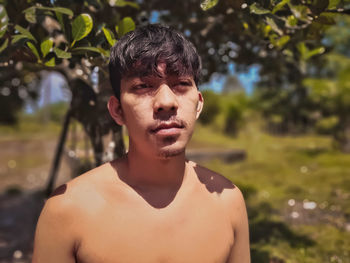 Portrait of shirtless man standing outdoors