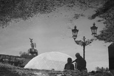 Rear view of man and woman walking against sky