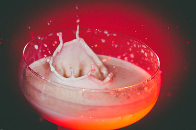 Close-up of drink splashing against red background