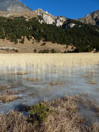 Scenic view of frozen lake and mountains against sky