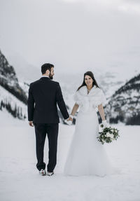Rear view of couple holding hands