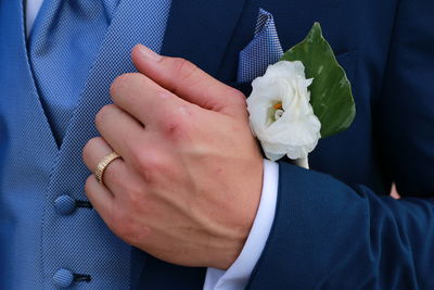 Midsection of bride with white rose