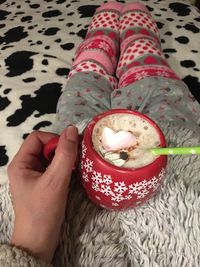 Midsection of woman holding ice cream cone on bed