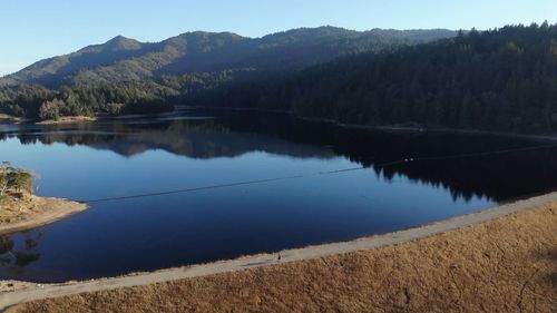 Scenic view of lake by mountains against sky