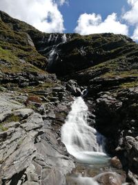 Scenic view of waterfall against sky