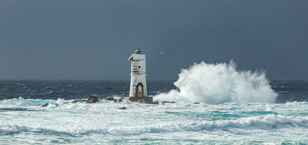 The lighthouse of the mangiabarche shrouded by the waves of a mistral wind storm
