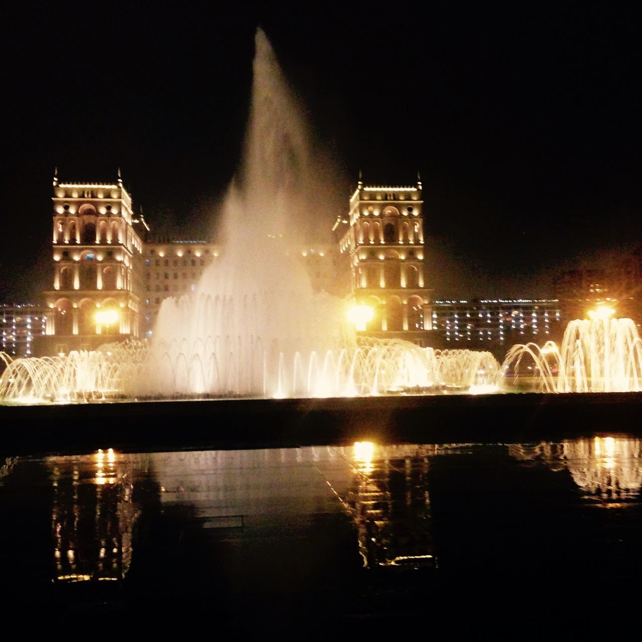 night, illuminated, water, architecture, built structure, building exterior, reflection, waterfront, city, river, long exposure, sky, fountain, motion, glowing, light - natural phenomenon, no people, travel destinations, lighting equipment, modern