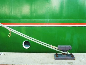 Rope tied to cleat on pier against boat