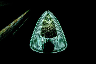 Close-up of illuminated lighting equipment against black background