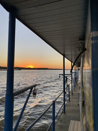 Pier over sea against sky during sunset