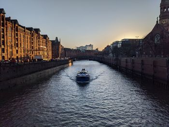 Bridge over river against sky during sunset
