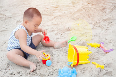 High angle view of boy playing with toy on beach