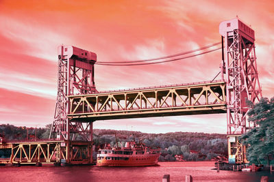 View of bridge over river against cloudy sky