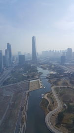 Aerial view of buildings in city against sky